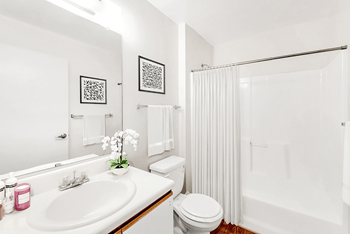 a bathroom with a white sink and toilet and a white shower curtain